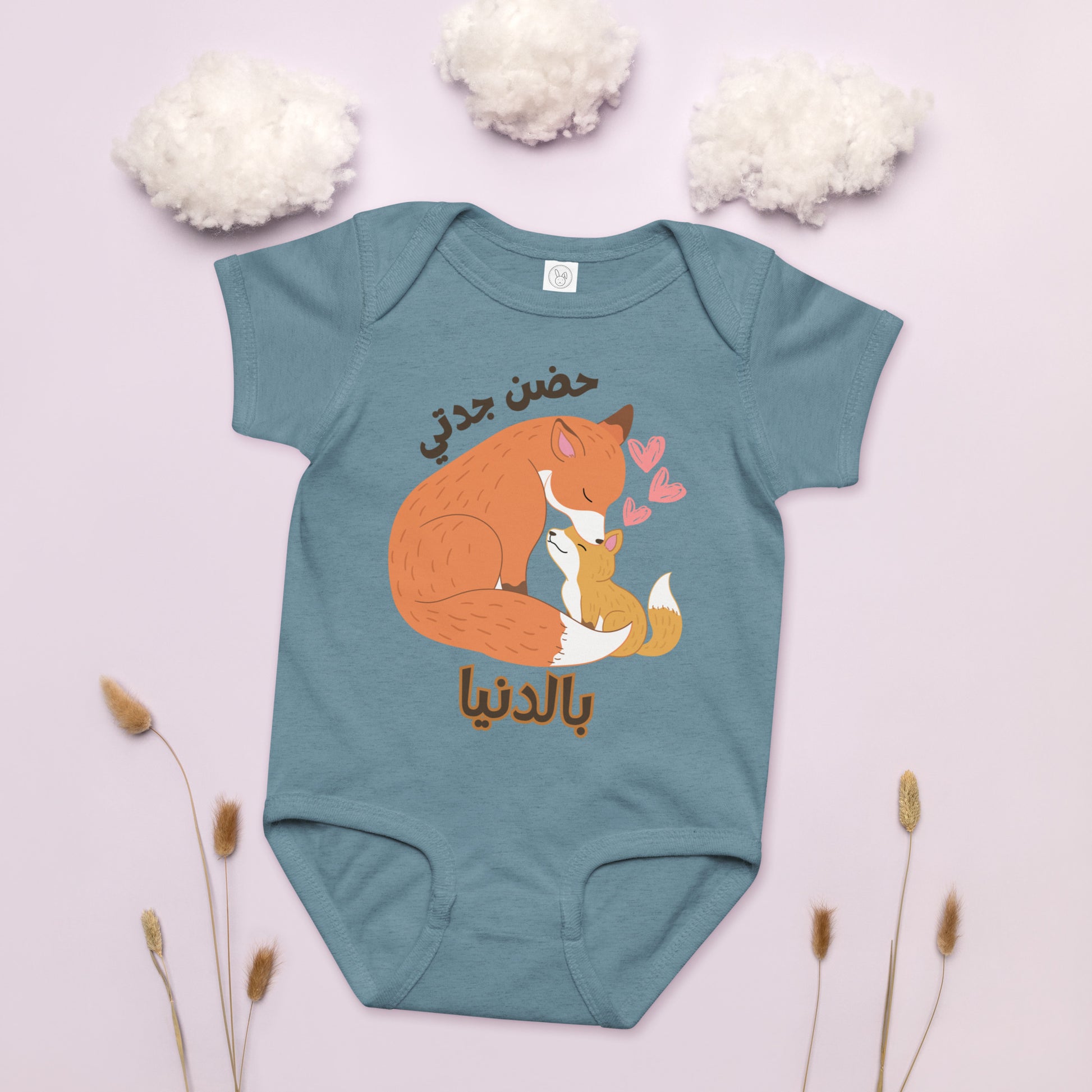 Grandma and baby foxes with hearts of love surrounding them. Arabic text that says Grandma hugs mean the world.
